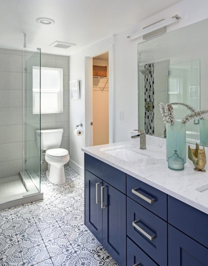 Custom bathroom interior with blue double vanity and glass shower.