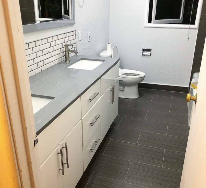 newly remodeled bathroom floor tiles, cabinet and sink